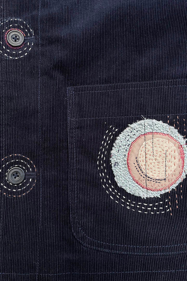 hand-stitched circular art on blue cord pocket