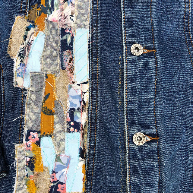 detail of tiny pieces of fabric sewn onto a denim jacket